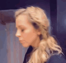 a close up of a woman 's face with blonde hair in a braid .