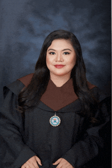 a woman in a graduation gown with a medallion that says ' philippines '