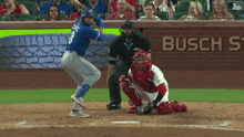 a blue jays player swings at a ball in front of a busch ad