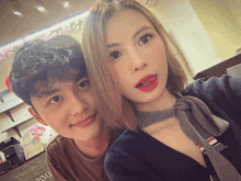 a man and a woman are posing for a picture and the woman has red lipstick