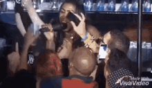 a woman is singing into a microphone in front of a crowd of people at a concert .
