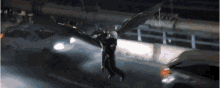 a person with wings is flying over a street with cars