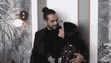 a man and a woman are standing in front of a door that says 301