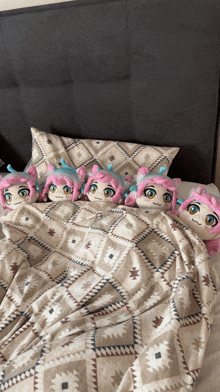a bed with a patterned blanket and pillows with pink and blue stuffed animals on it