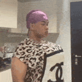 a person wearing a leopard print shirt with a chanel logo on the front