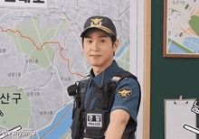 a police officer stands in front of a map with chinese writing on it