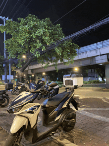 a honda scooter is parked on the side of the road at night