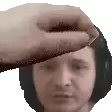a hand is touching a man 's forehead with headphones on .