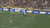 a soccer game is being played on a field with a visa sign in the background