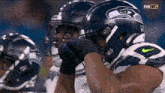 a group of football players wearing seahawks helmets are watching a game on fox nfl