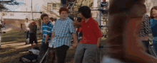 a group of kids are standing in a park holding hands and talking