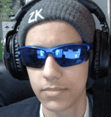 a boy wearing headphones and sunglasses has a zk hat on