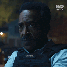a man is wearing a vest with the name a.r.g.u.s. on it