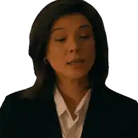 a woman in a black suit and white shirt looks serious