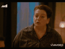 a woman in a polka dot shirt is on a tv screen with vivavideo written on the bottom right
