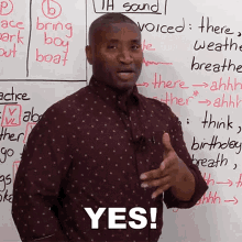 a man stands in front of a white board with the word yes on it