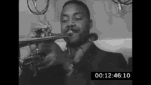 a man is playing a trumpet in a black and white photo .
