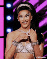 a drag queen wearing a headband and bracelets is smiling .