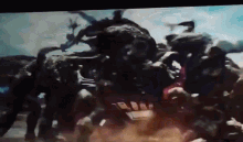 a group of monsters are fighting each other in a dark room .