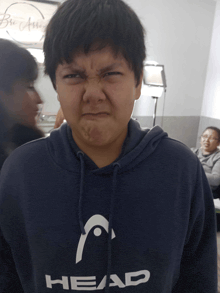 a boy wearing a blue head hoodie makes a funny face