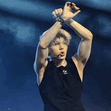 a man wearing a black tank top that says ' x nation ' on it