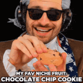 a man wearing sunglasses and headphones holds a chocolate chip cookie