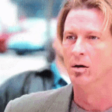 a close up of a man 's face with a surprised look on his face