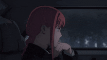 a girl with red hair is sitting in a dark room