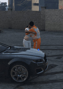 a man and a woman hugging in front of a car with a brick wall in the background