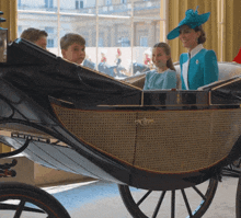 a woman in a blue jacket is sitting in a horse drawn carriage