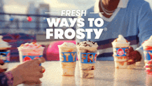 a person sitting at a table with cups of frosty ice cream