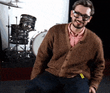 a man wearing glasses and a brown sweater has a yellow tag on his pants that says ' i love you '