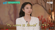 a woman is sitting in front of a microphone on a tv show and talking about her name .
