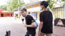 a man wearing a black shirt that says adidas on it
