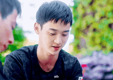 a young man wearing a black t-shirt that says yeah on it
