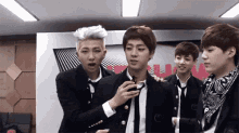 a group of young men are standing in a room .