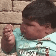 a very fat boy is eating a slice of pizza .
