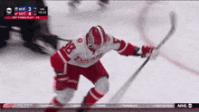 a hockey player in a red and white uniform with the number 18 on it