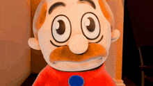 a stuffed toy with a mustache and big eyes is standing in a room .