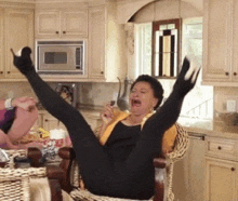 a woman is sitting in a chair with her legs up in the air while talking on a cell phone .