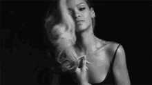 a black and white photo of a woman with long hair and a tattoo on her chest .