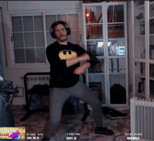 a man wearing headphones and a batman shirt dancing