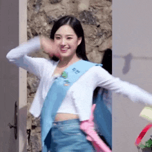 a woman wearing a blue sash and a white cardigan is standing in front of a door .