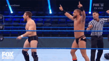 two wrestlers are in a ring with a referee and a fox logo