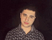a man wearing a black and grey shirt with a pattern of birds on it