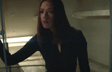 a woman with red hair is standing in a room