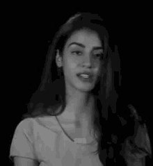 a black and white photo of a woman wearing a necklace that says swg on it