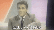 a man in a suit and tie is saying `` call ya in 2 and 2 '' .