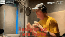 a man wearing headphones is singing into a microphone with the words ready or not here i come in red