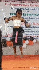 a woman is dancing in front of balloons and a sign that says 1st anniversary celeb